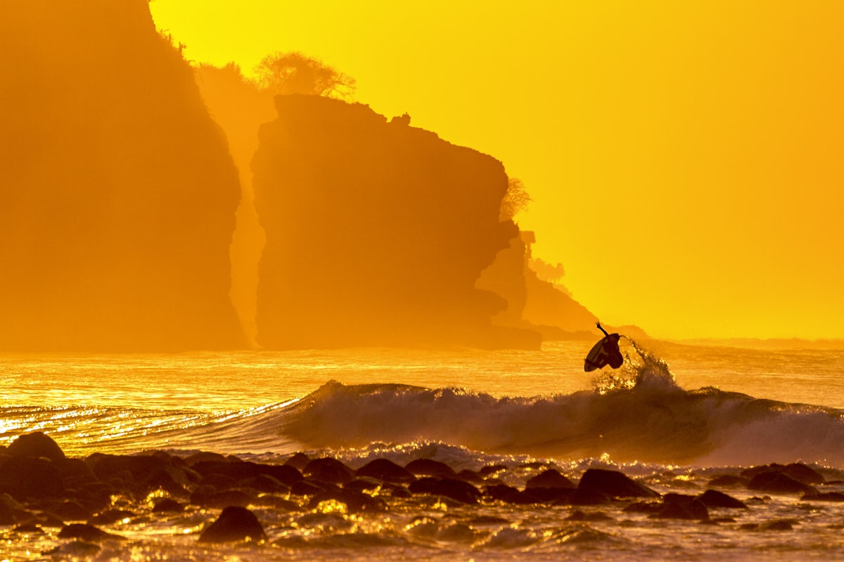 Surfer walking with board at sunrise